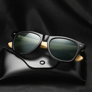 Óculos de sol Bamboo modelo dia a dia em ângulo frontal em cima de um estojo preto na cor preto com lente verde escuro, disponível em: ethosloja.com.br