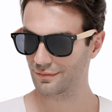 Óculos de sol Bamboo modelo dia a dia em um modelo masculino na cor preto com lente preta, disponível em: ethosloja.com.br