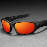 Óculos de sol Pro modelo esportivo em ângulo lateral apoiado em uma superfície cinza na cor preto com lente vermelha, disponível em: ethosloja.com.br